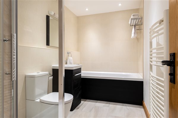 Family bathroom with shower enclosure and large bath.